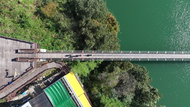View of a Suspension Bridge with Scenic Lake and Forests