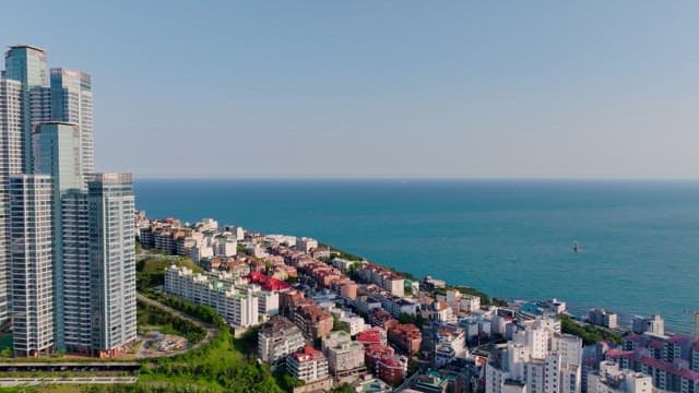 Coastal city with tall skyscrapers and dense residential complex by the sea