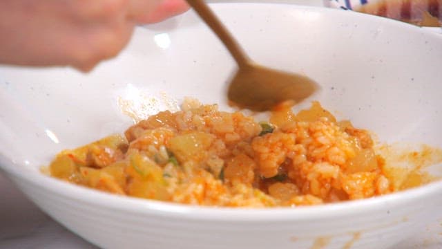Rice bowl with stir-fried radish and pork mixed with a spoon