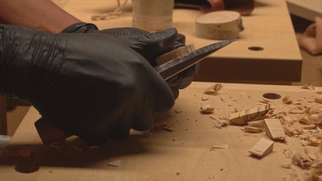 Hands carving wood with precision