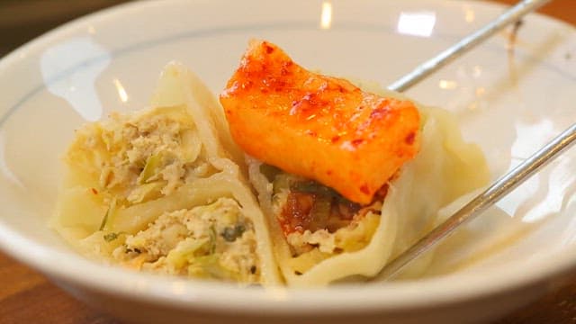 Pyongyang-style dumplings topped with radish kimchi