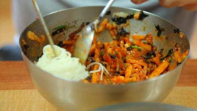 Putting noodles in sliced raw fish