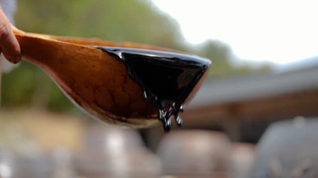 Pouring Soy Sauce from a Wooden Bowl