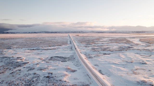 Snowy road stretching through a vast landscape
