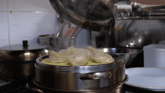 Steamed dumplings being prepared in a kitchen