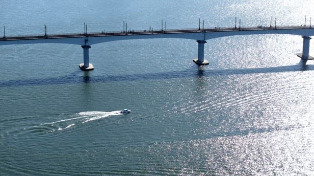 Boat sailing under a bridge on a sunny day