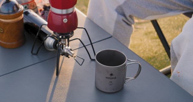 Pouring hot beverage outdoors at campsite