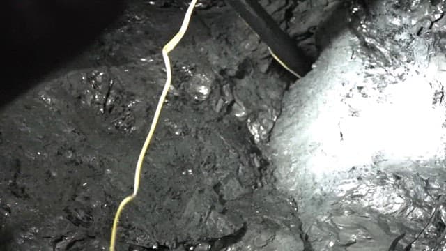 Worker placing explosive charges in a coal mine