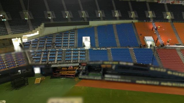 Quiet stadium with scattered garbage and empty seats
