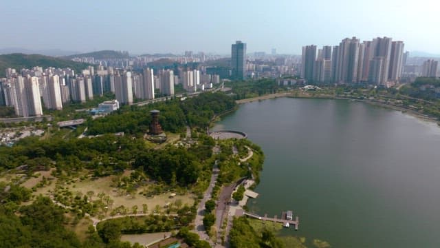A cityscape with a park and lake