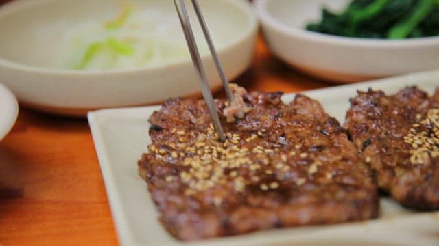 Tteokgalbi on a table with side dishes