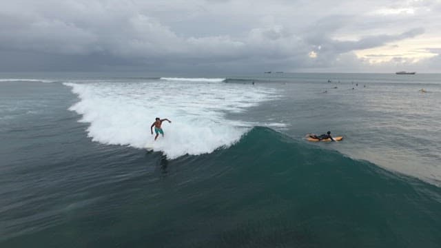 Surfers Riding Waves in Open Sea