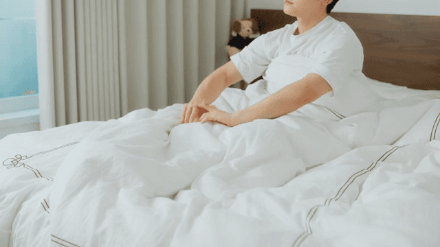 Man waking up and checking phone in bed