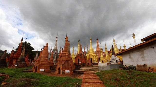 Buddha statues and stone pagodas lined up densely under a cloudy sky