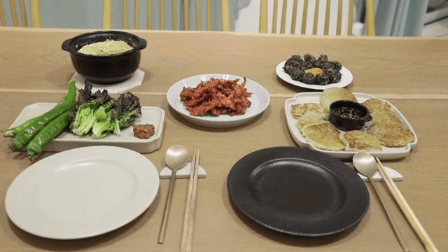 Table set with various Korean dishes such as chicken feet, steamed eggs and rice balls