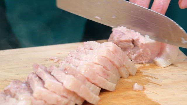 Chef Slicing Meat on a Cutting Board