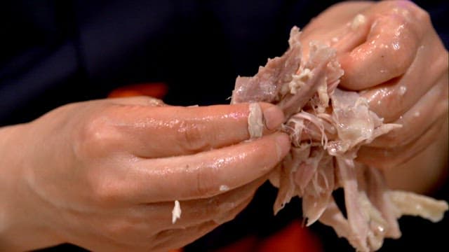 Ripping the cooked chicken by hand