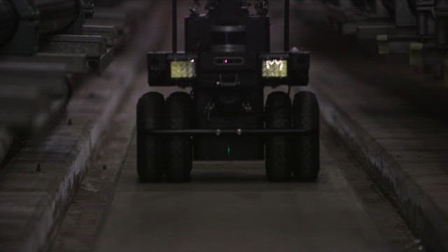 Autonomous robot navigating through a dimly lit industrial facility