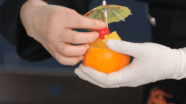 Preparing a fruit dessert with oranges and cherries