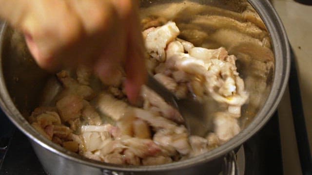 Stirring pork belly in a pot