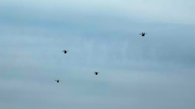 Four helicopters flying in the sky