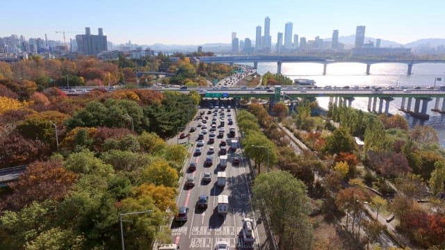 City highway with autumn foliage and river
