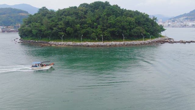 Boat sailing near a lush green island