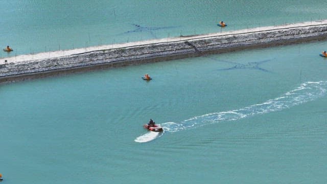 Small boat navigating a fish farm