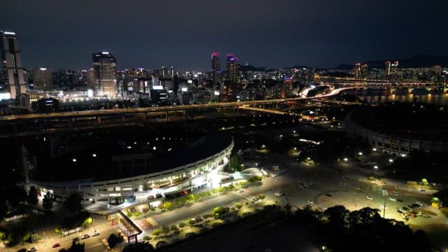 Nighttime Cityscape with Illuminated Buildings and Stadium