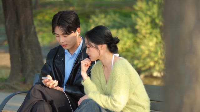 Couple sharing earphones on a park bench