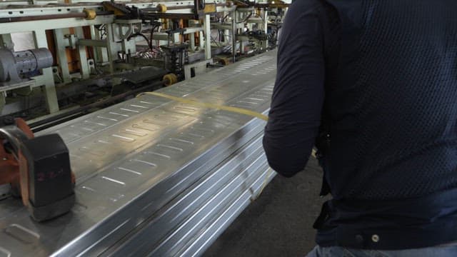 Worker securing metal sheets in a factory