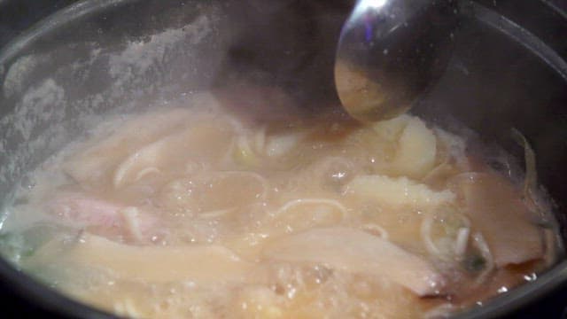 Mashing potatoes for noodle soup with chicken