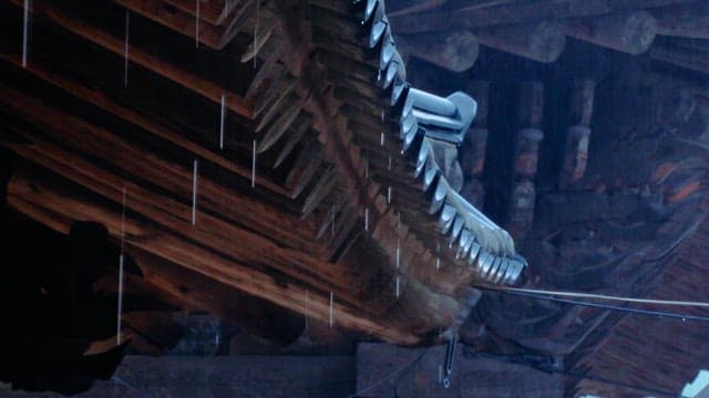 Rain falling on the wooden roof of a temple
