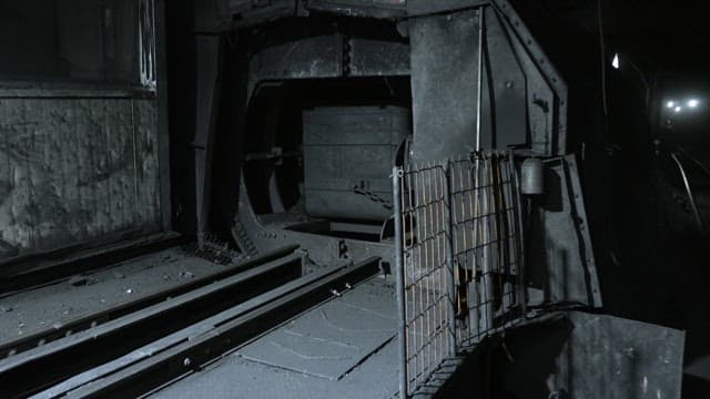 Coal being transported on an industrial machine in a dimly lit mine