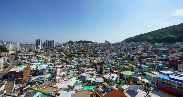 Day to night view of a densely populated residential area on a hill