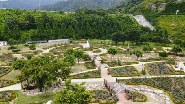 Park with many green trees and a sculpture in the center