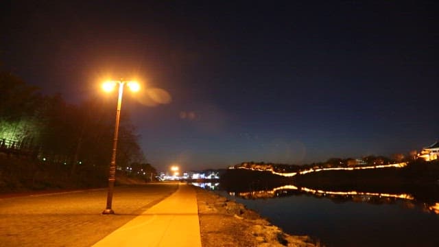 Serene Night at Riverside with Illuminated Walkway