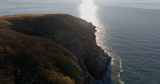 Serene Coastal Landsacape with Sun Reflecting on Water