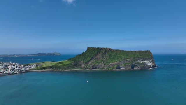 Seongsan Ilchulbong with Lush Greenery and Serene Sea on a Sunny Day