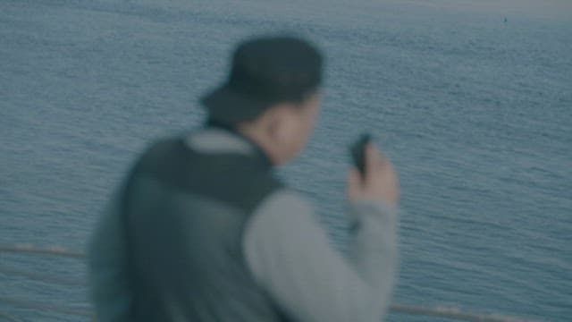 Man Calling with Cell Phone Near the Ocean