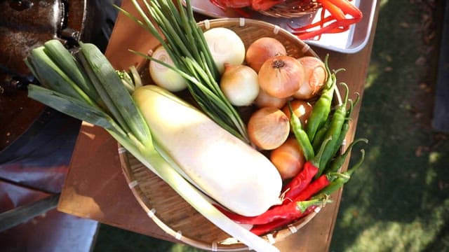 Assortment of fresh vegetables and seafood on a table, ready for cooking.