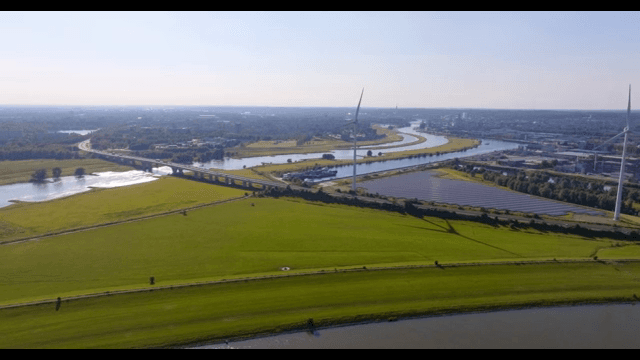 Scenic view of a river with wind turbines