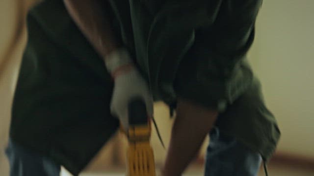Worker Lifting Wooden Floor with Tool