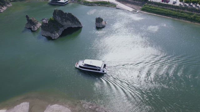 Cruise Passing by a Rocky Island on a Peaceful River