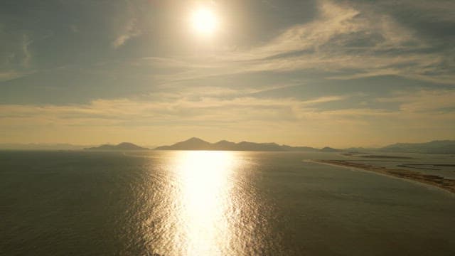 Sunlit sea with distant mountains