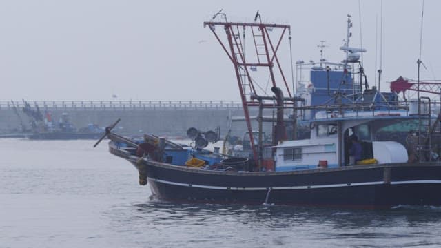 Fishing boats sailing near harbor lighthouse