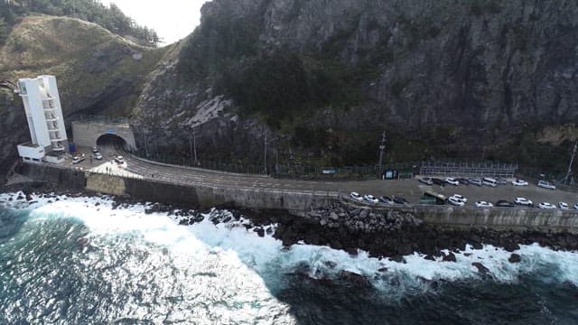 Coastal Road by Steep Cliffs and Turbulent Wave