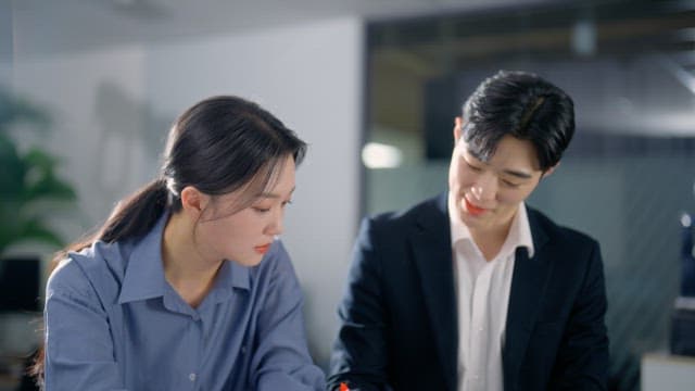 Two colleagues discussing documents