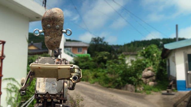 Robot reading something outside in the countryside on a sunny day