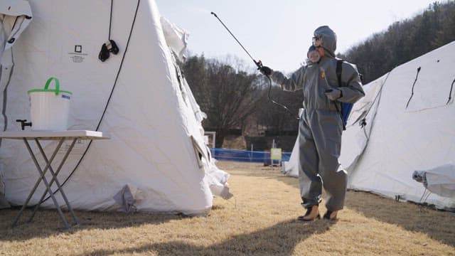 Health Worker Disinfecting Outdoor Emergency Tents